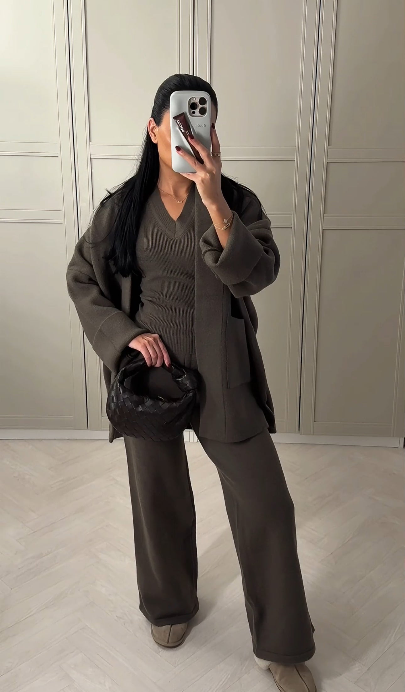 Woman wearing Alaia 3 piece knit set with wide-leg pants, fitted top and matching long cardigan