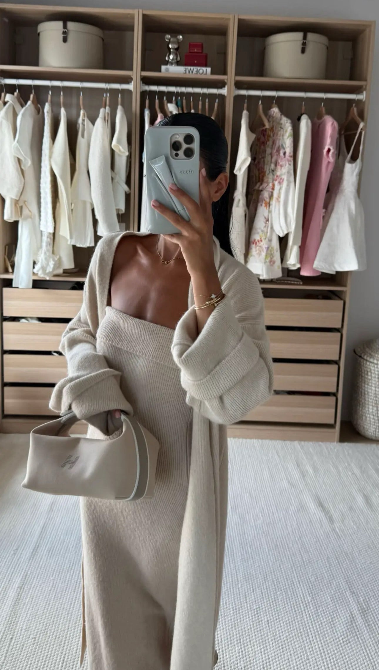 Woman wearing a luxury beige knitted two-piece dress set with strapless maxi dress and matching long knit cardigan