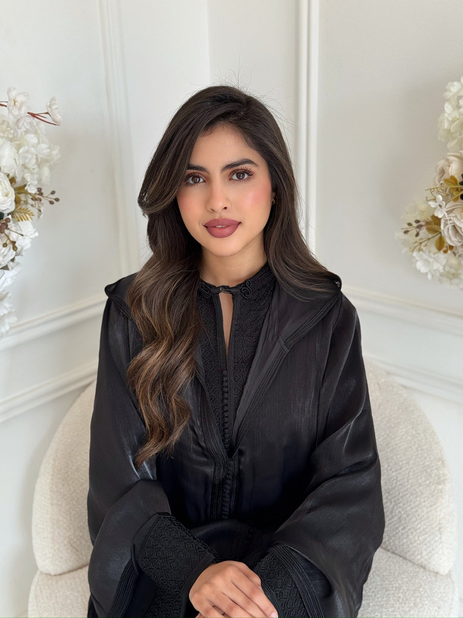 Model wearing luxury black Moroccan jellaba Rokaya in elegant interior